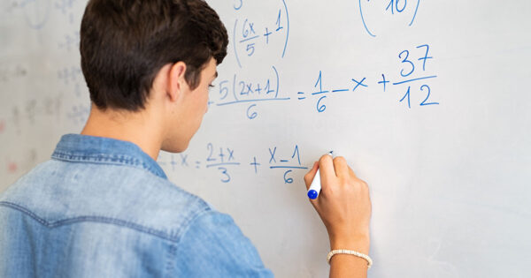 A student doing math on a dry-erase board