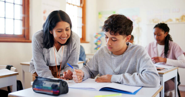 A teacher assists a student in a classroom