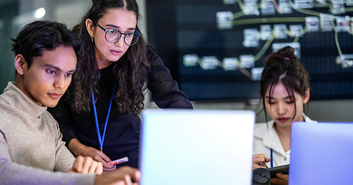 Three adults working on laptops