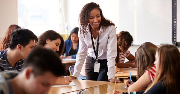 Teacher with students in high school classroom