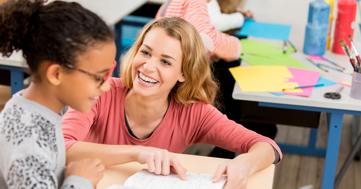 Image of a teacher helping a student in the classroom